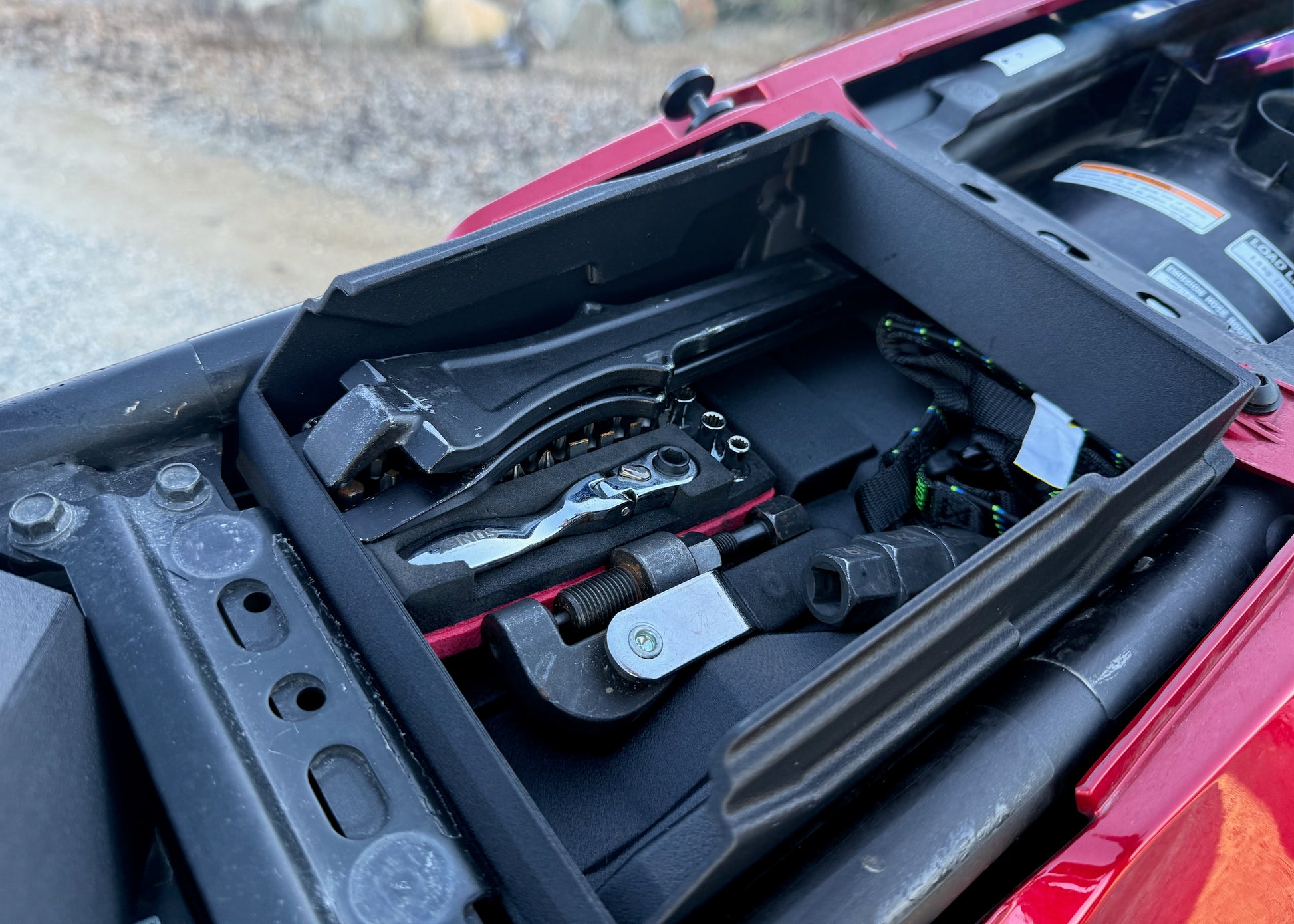 MotoCubby Scout Yamaha Ténéré 700 — close-up of the OEM Yamaha tool kit fitted in the factory tool tray next to the Scout