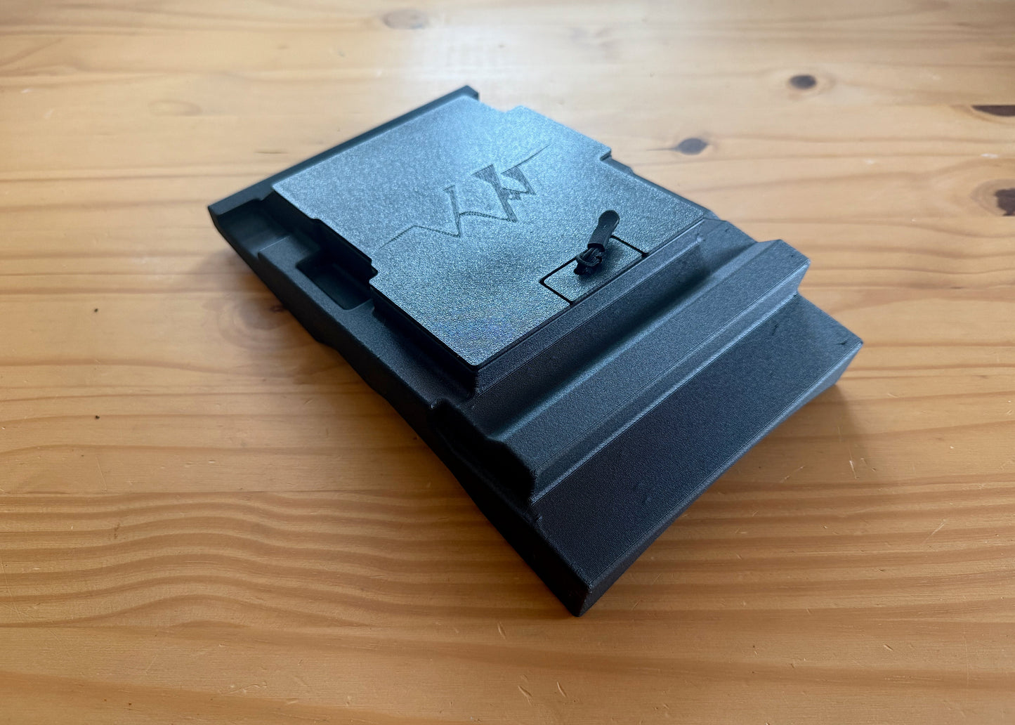 MotoCubby Nomad III under-seat storage for Yamaha Ténéré 700 — close-up of the lid pull-tab and M logo embossing