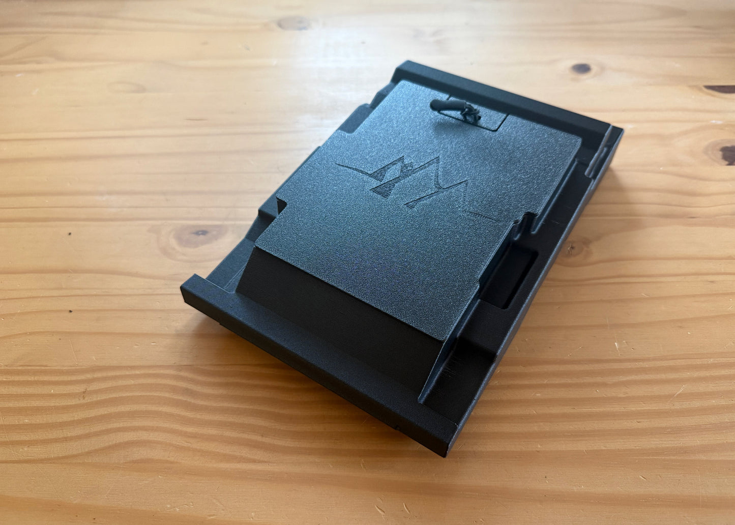 MotoCubby Nomad III under-seat storage for Yamaha Ténéré 700 — flatter angle showing the M logo lid and tabbed shell profile