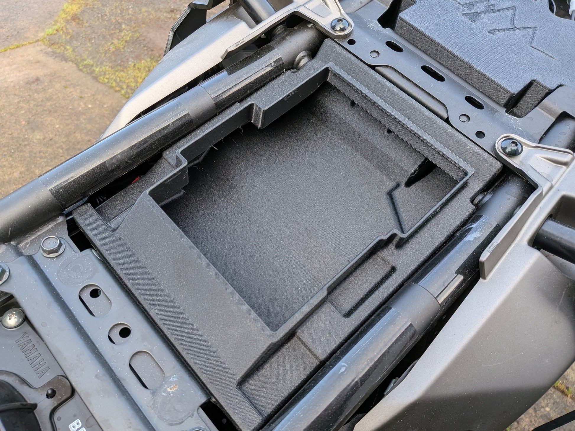 MotoCubby Drifter II installed under the pillion seat of a 2025 Yamaha Ténéré 700 — empty box body showing the rear storage compartment